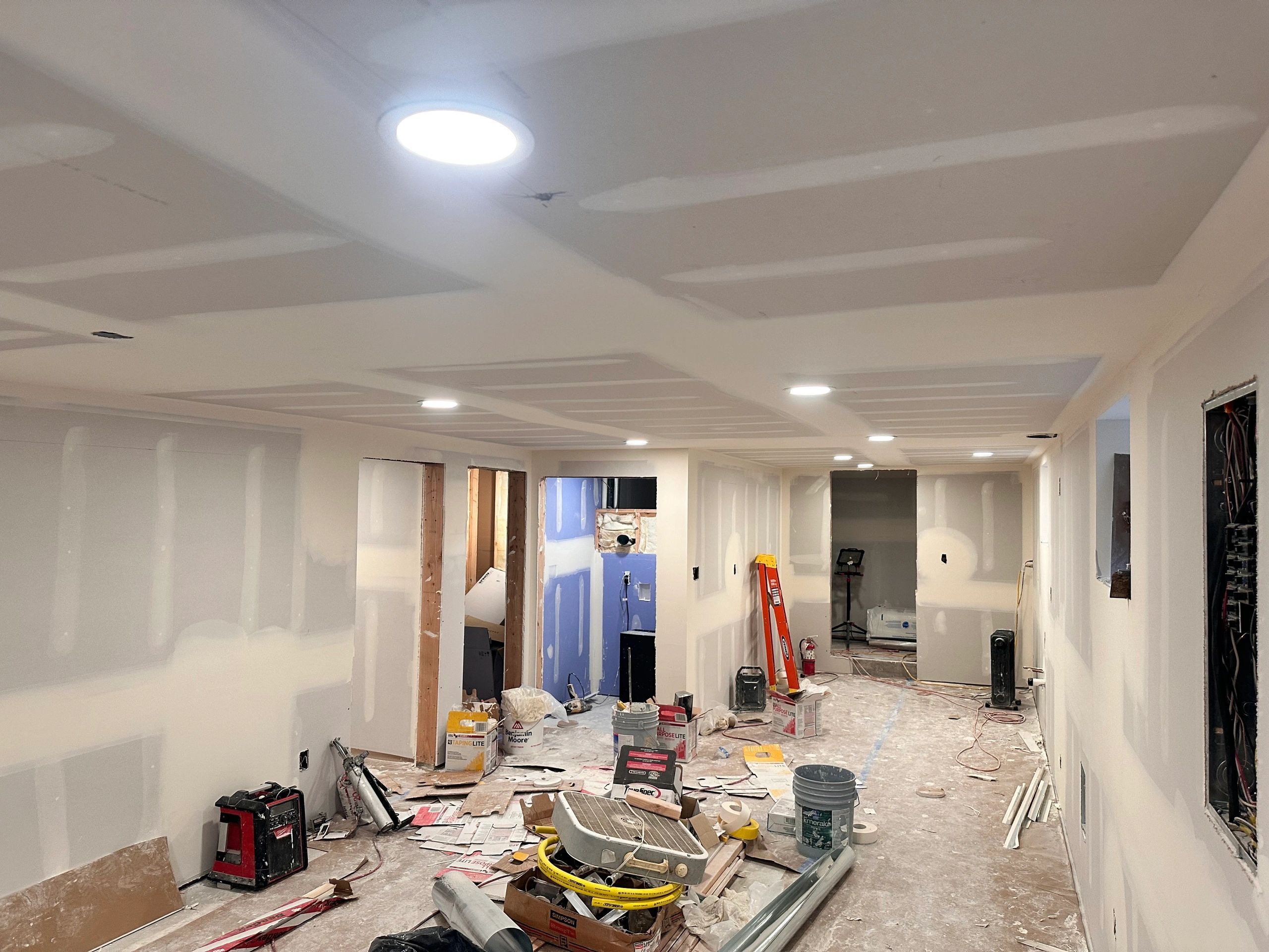 Basement remodel in progress with new recessed lighting installed in the ceiling
