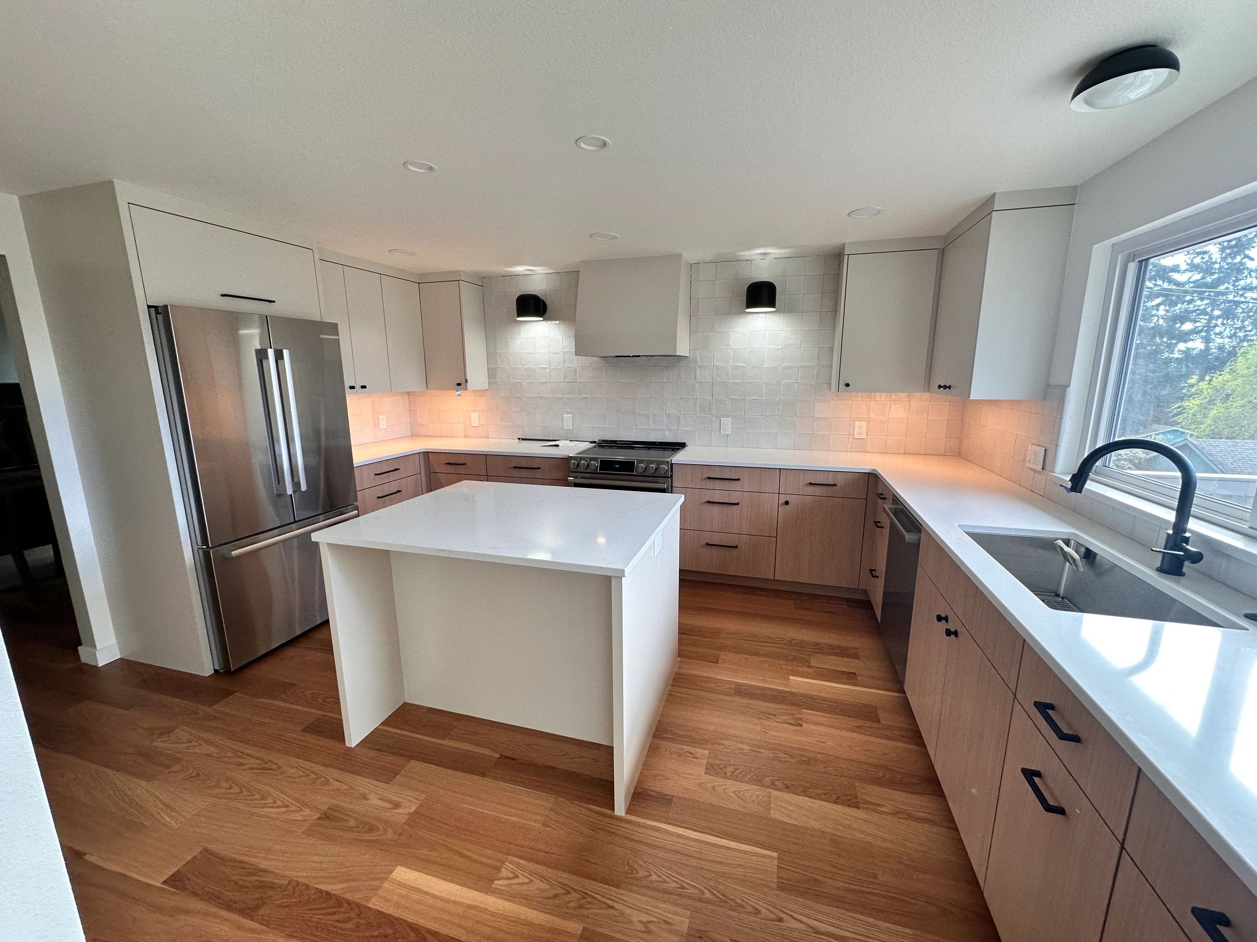 Remodeled kitchen with island, under-cabinet lighting and flush ceiling fixtures