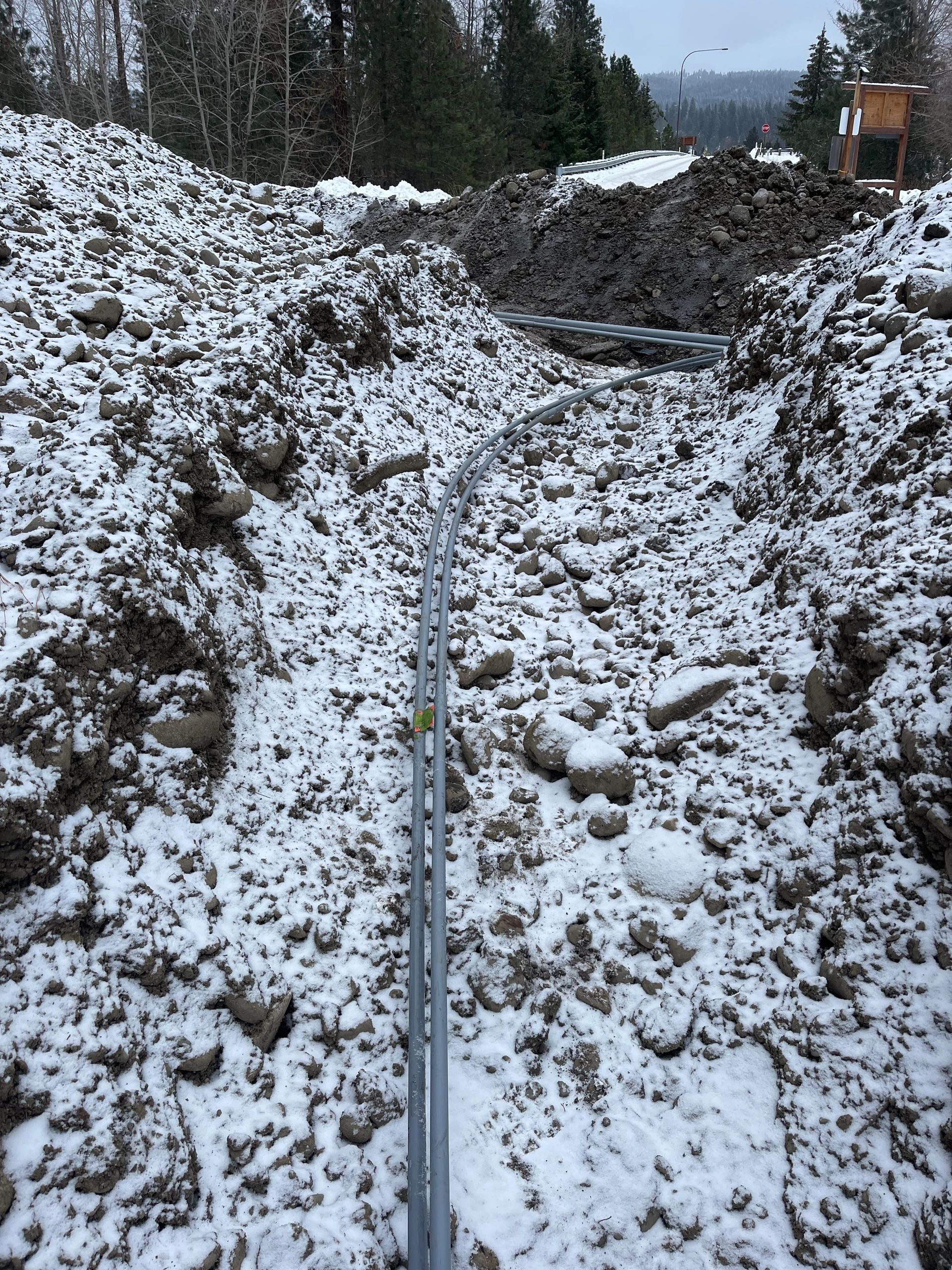 Conduit laid in a snow-covered trench for an underground electrical service