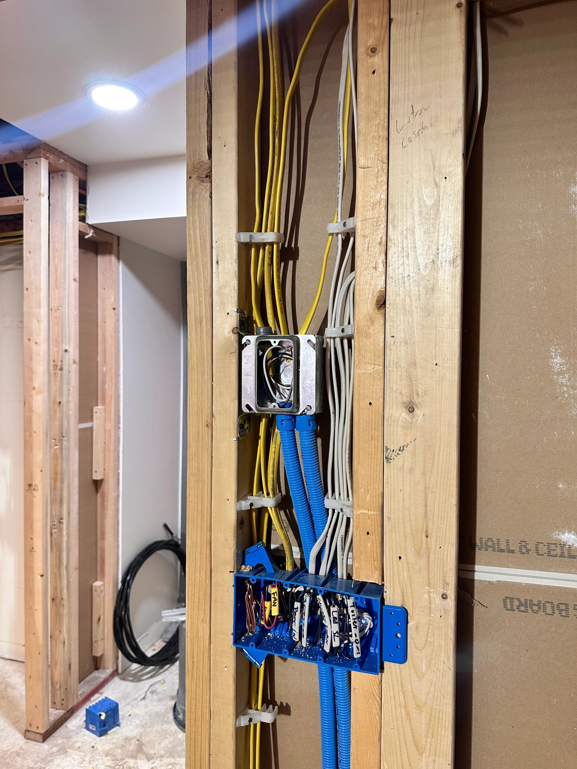 Rough-in wiring run neatly through framed walls to device boxes before drywall