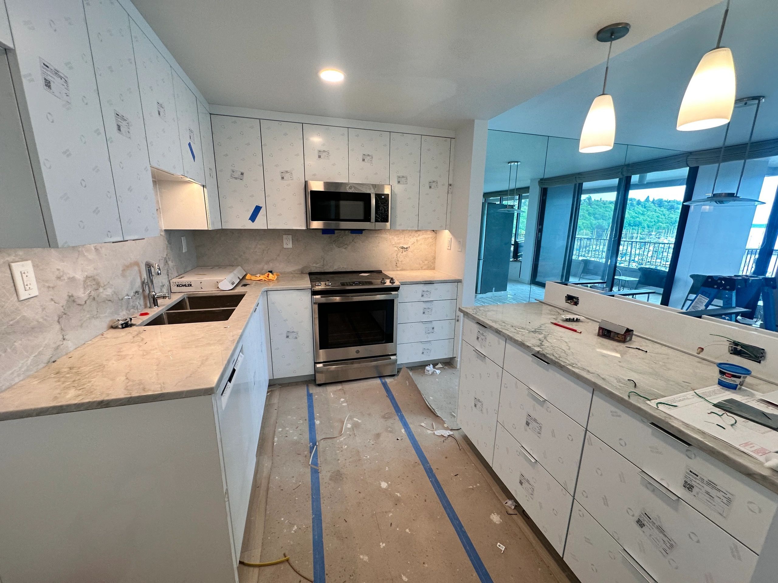 Kitchen nearing completion with pendant lights over the counter and recessed lighting